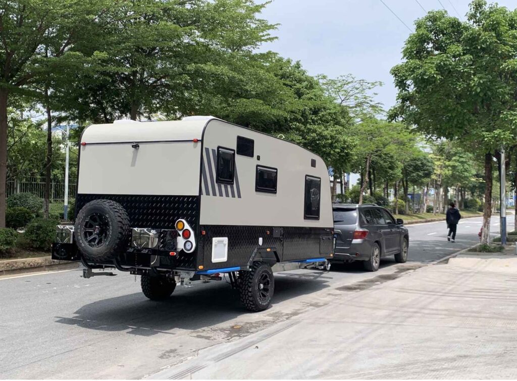 Off Road Camping Trailer Being Towed By A Small SUV On Street