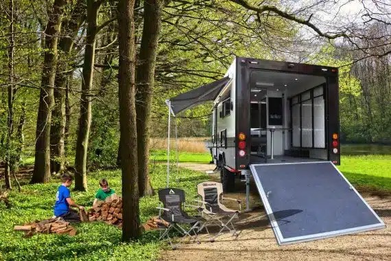 Small Toyhauler camper with family in woods
