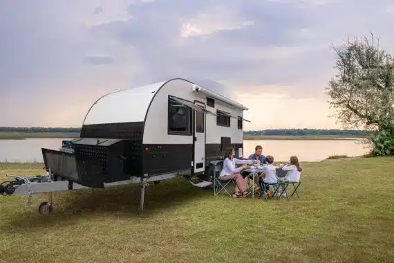 Family enjoying a meal while camping by the lake